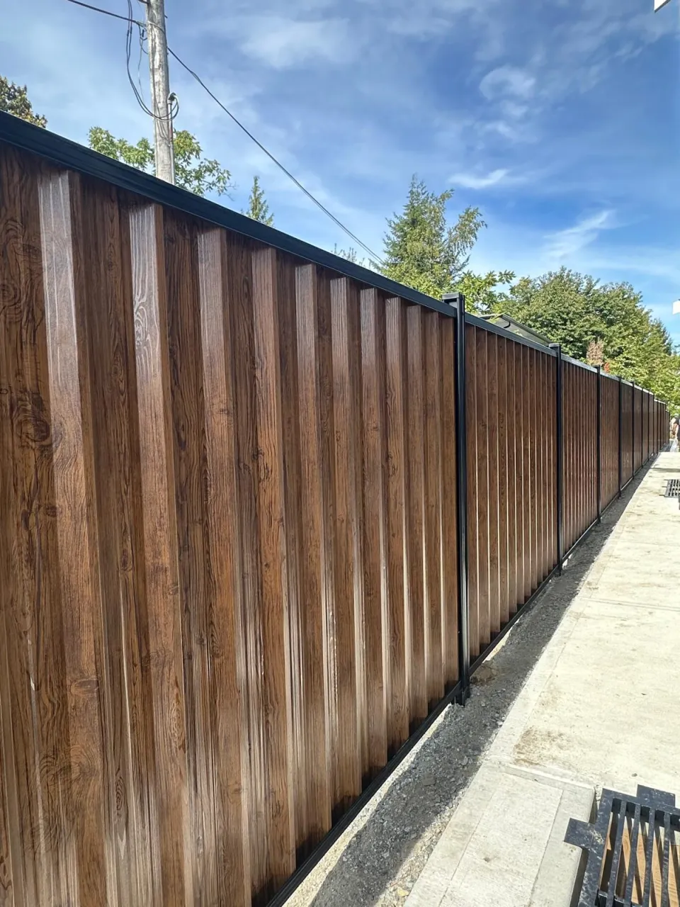 Stained cedar board fence along a property line
