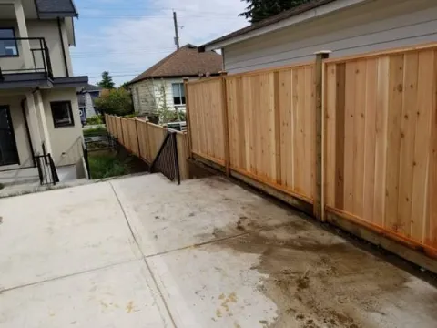 Cedar privacy fence beside a new concrete patio