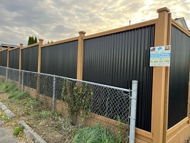 Cedar-framed steel fence with cedar post caps along a roadside