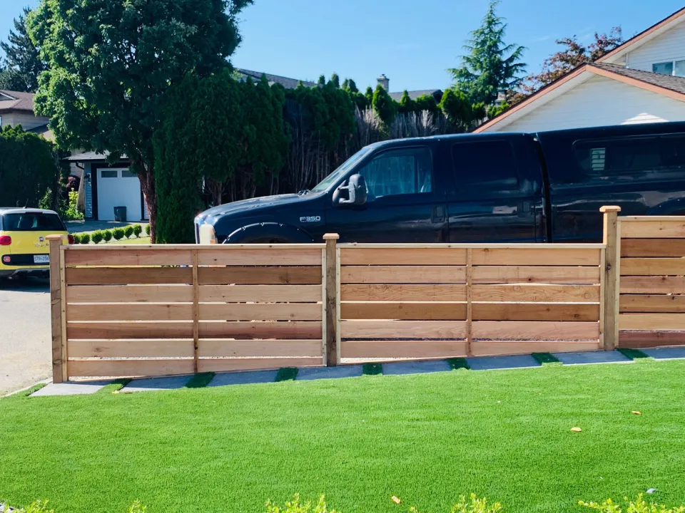 Horizontal cedar fence along a front lawn