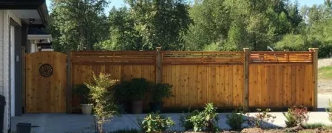 Horizontal cedar fence and gate behind planter beds