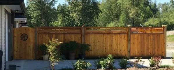 Horizontal cedar fence and gate behind planter beds