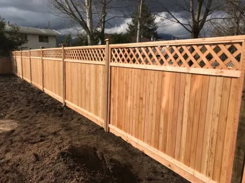 Cedar fence with a diagonal lattice top on a new build lot