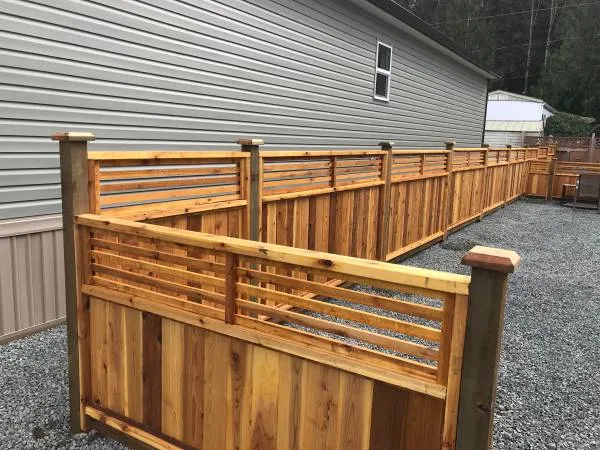 Corner of a cedar fence with a horizontal slat top