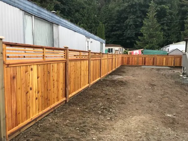Cedar fence with a horizontal slat top around a new yard